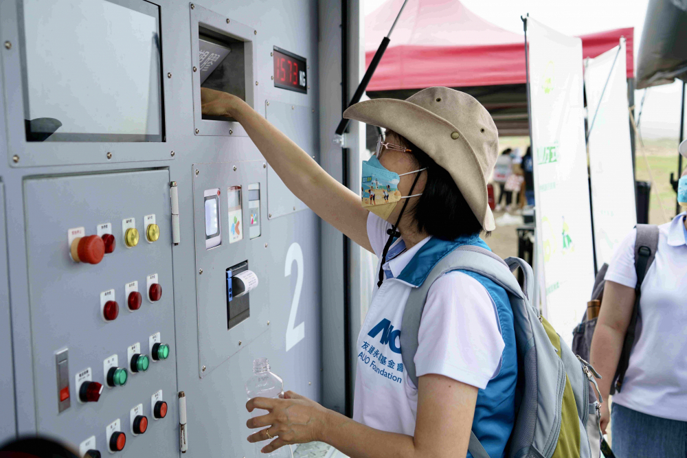 志工們將拾起的寶特瓶投入「好歸塑專車」，讓廢棄塑料空瓶可以直接粉碎、縮小體積，未來將可再製成購物袋、寶特衣、悠遊卡等生活用品